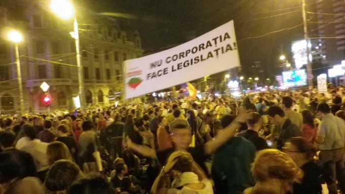 Protests against the cyanide gold-mining project planned at Roșia Montană in Romania. University Square, Bucharest, September 2013. The banner says “It is not the corporation making the legislation.” The protests lasted for three months, with marches crossing and occupying streets in the entire capital and in other cities in the country. The laws allowing for the project to begin were at that time stopped, and later sustained efforts from civil society, activist groups, and some politicians prevented other subsequent attempts of the Canadian company to start mining in that region. The latest update is that the Ministry of Culture in Romania managed to successfully submit to UNESCO an application for the Roșia Montană site to be considered as a world heritage site. . Photo: Raluca Voinea